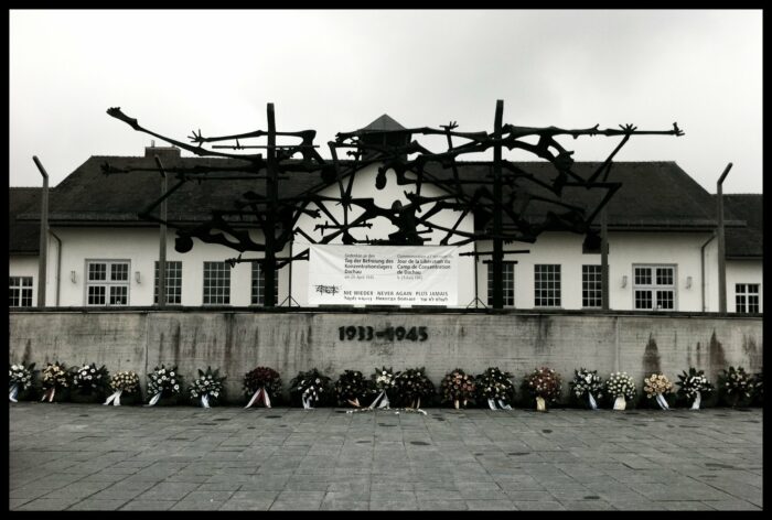 Gebäude der KZ-Gedenkstätte Dachau mit Denkmal und sowie mit Kränzen zum Tag der Befreiung des KZ Dachau. Foto von 2011.